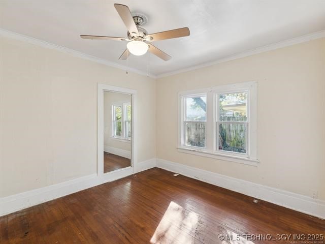 spare room with dark hardwood / wood-style flooring, ceiling fan, and crown molding