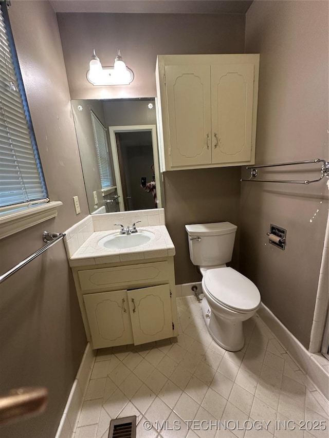 bathroom featuring tile patterned flooring, vanity, and toilet