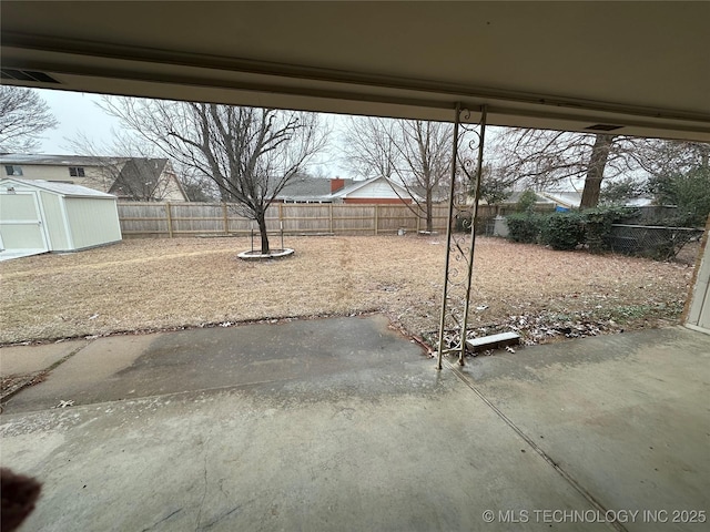 view of yard with a storage shed and a patio