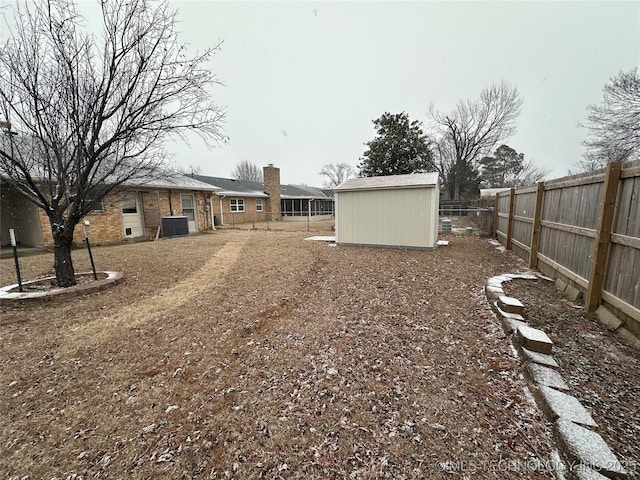 view of yard with central air condition unit and a storage unit