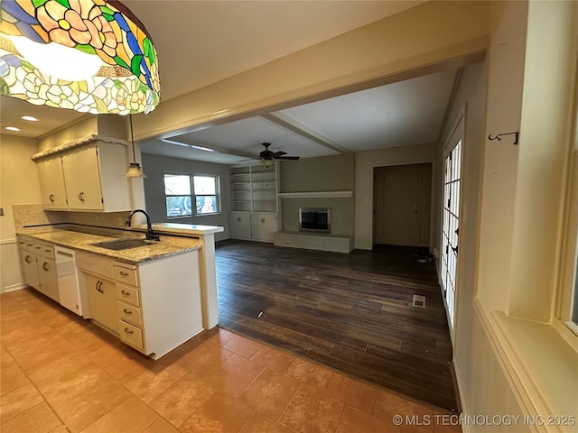 kitchen with sink, dishwasher, ceiling fan, white cabinets, and decorative light fixtures