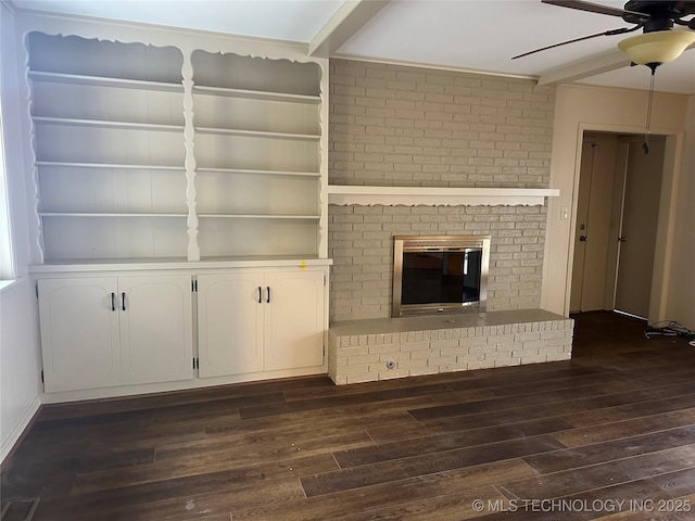 unfurnished living room with ceiling fan, dark hardwood / wood-style floors, and a brick fireplace