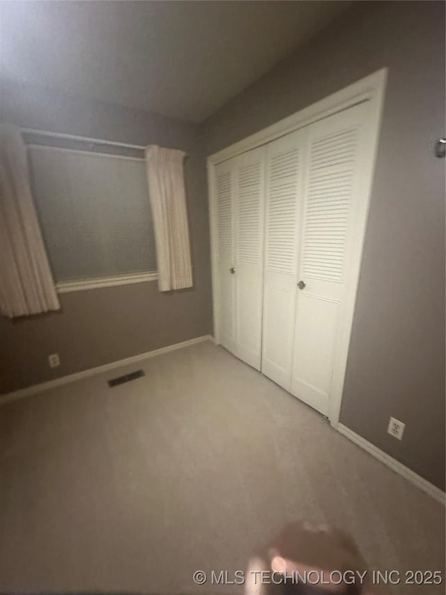 unfurnished bedroom featuring carpet floors and a closet