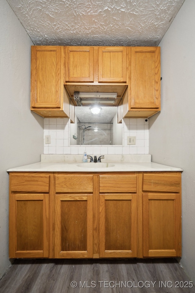 kitchen featuring dark hardwood / wood-style flooring, tasteful backsplash, and sink