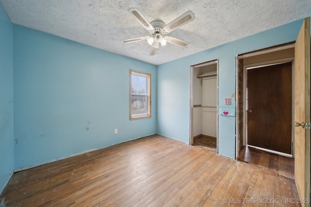 unfurnished bedroom with hardwood / wood-style flooring, ceiling fan, and a textured ceiling