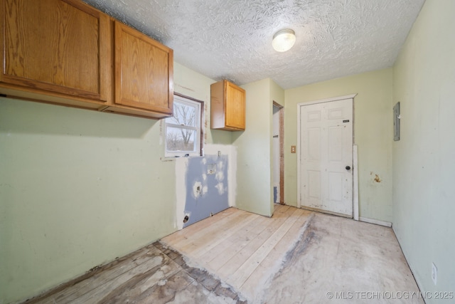 laundry area featuring cabinets and a textured ceiling