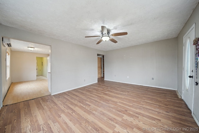 empty room featuring ceiling fan, light hardwood / wood-style flooring, and a textured ceiling