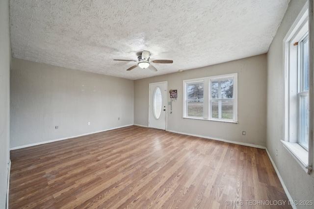 interior space with hardwood / wood-style flooring, ceiling fan, a textured ceiling, and a wealth of natural light