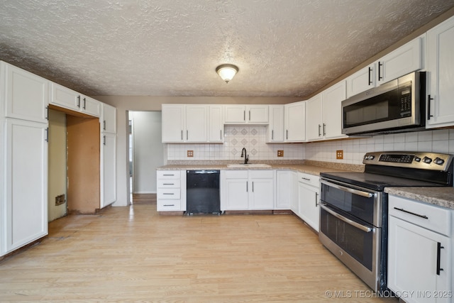 kitchen featuring white cabinets, appliances with stainless steel finishes, and sink