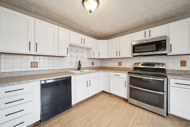 kitchen featuring sink, light wood-type flooring, a textured ceiling, appliances with stainless steel finishes, and white cabinetry