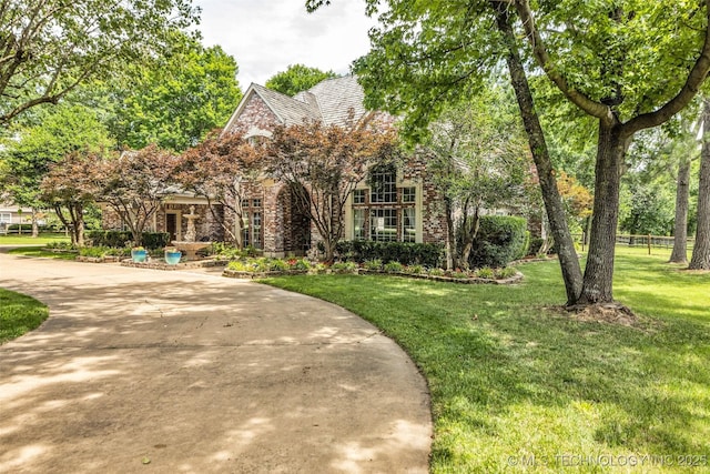 english style home featuring a front yard