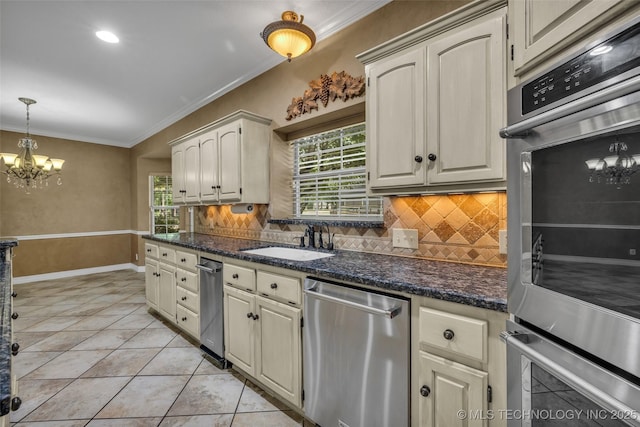 kitchen featuring sink, stainless steel appliances, an inviting chandelier, tasteful backsplash, and light tile patterned floors