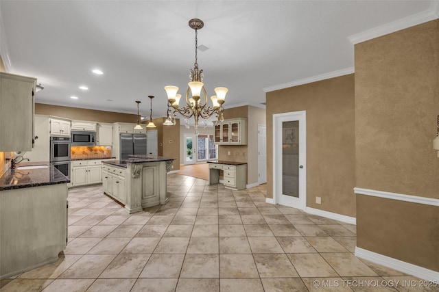 kitchen with built in appliances, a sink, ornamental molding, a center island, and decorative light fixtures