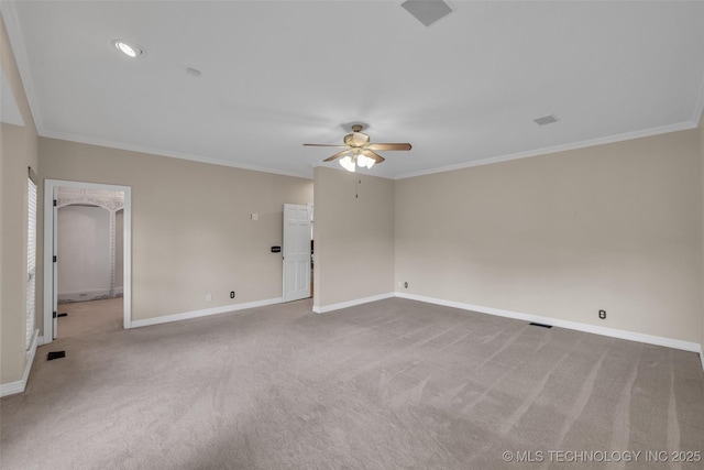 spare room with ornamental molding, light colored carpet, visible vents, and baseboards