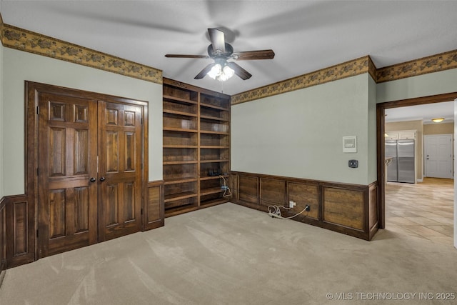 carpeted home office featuring built in features, ceiling fan, and wood walls