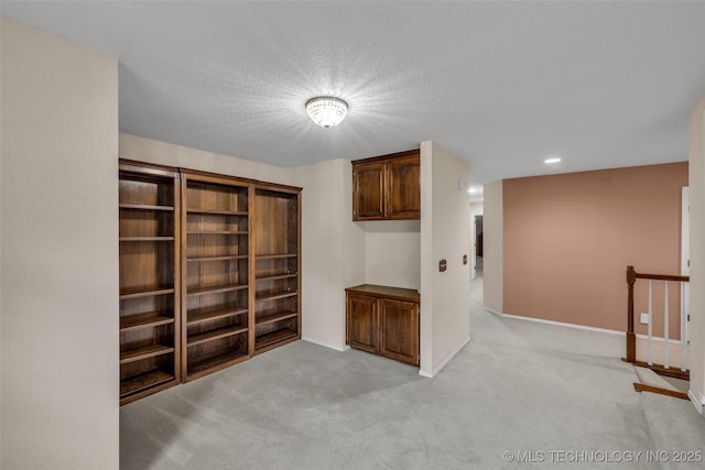 unfurnished room with light carpet and a textured ceiling