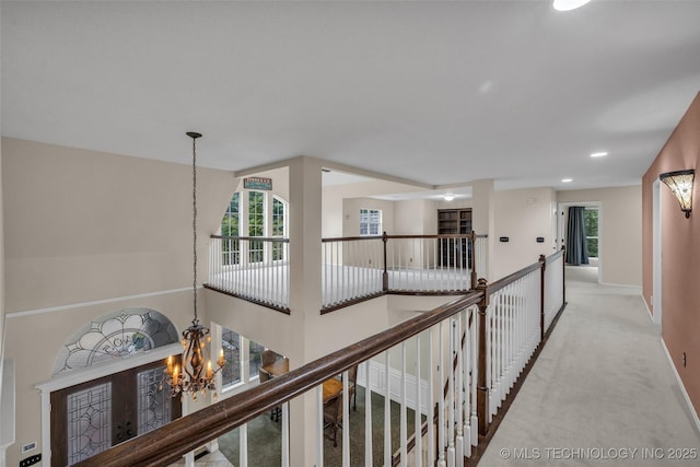 hallway featuring recessed lighting, light colored carpet, an inviting chandelier, an upstairs landing, and baseboards