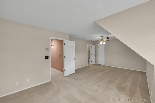 bonus room featuring light carpet, ceiling fan, and baseboards