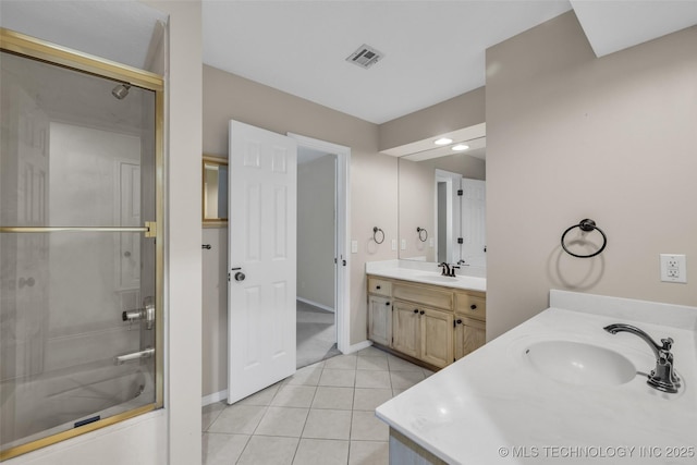 full bathroom featuring bath / shower combo with glass door, visible vents, vanity, baseboards, and tile patterned floors