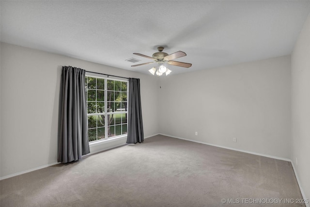 spare room featuring a textured ceiling, ceiling fan, and light carpet