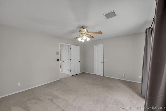 empty room with light carpet, baseboards, visible vents, and a ceiling fan