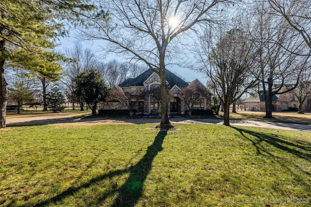 view of front of house with stone siding and a front lawn