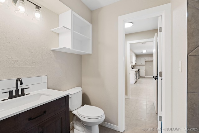 bathroom featuring tile patterned floors, decorative backsplash, vanity, and toilet