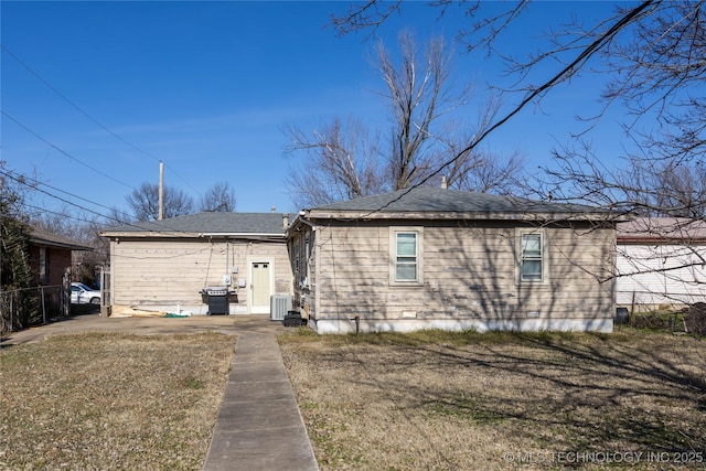 rear view of house with a lawn and central AC