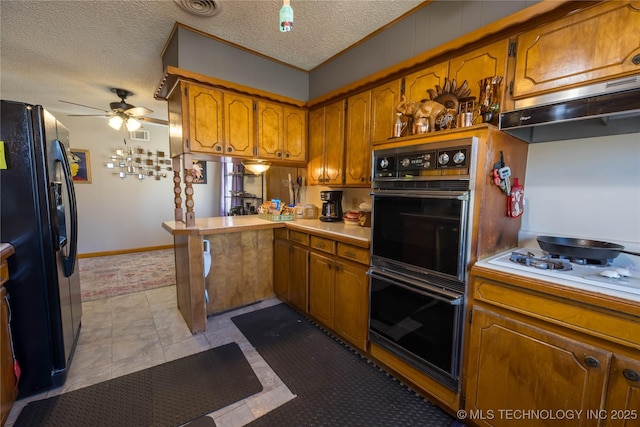 kitchen featuring kitchen peninsula, a textured ceiling, ceiling fan, black appliances, and light tile patterned floors