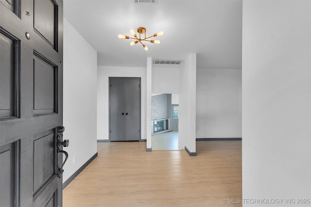 entryway featuring light hardwood / wood-style flooring and an inviting chandelier