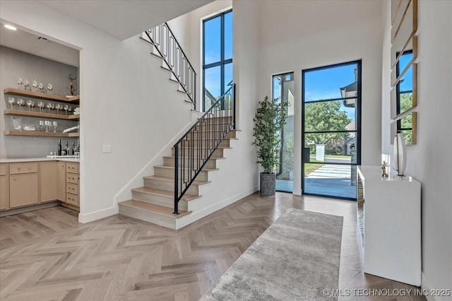 5835 E 139th St S, Bixby, OK 74008 - foyer entrance featuring stairway, wet bar, and a towering ceiling