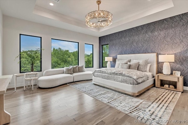 5835 E 139th St S, Bixby, OK 74008 - bedroom featuring a raised ceiling, a chandelier, wood finished floors, an accent wall, and recessed lighting
