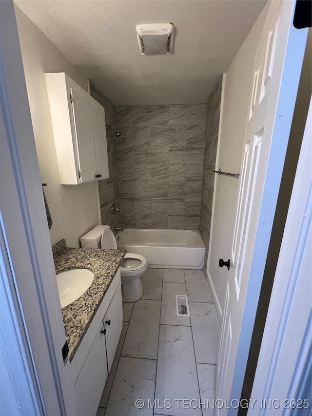 full bathroom with vanity, tiled shower / bath, and toilet