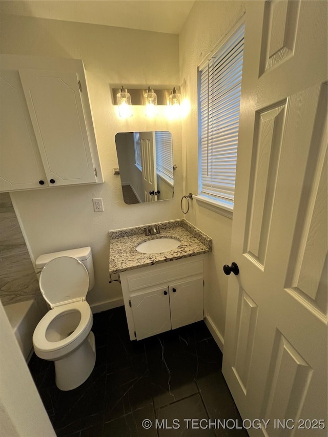 bathroom with toilet, vanity, and tile patterned floors