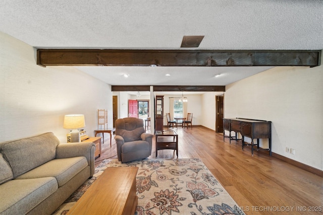 living room featuring beam ceiling, a textured ceiling, and hardwood / wood-style floors