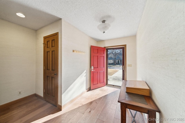 foyer entrance with hardwood / wood-style floors and a textured ceiling