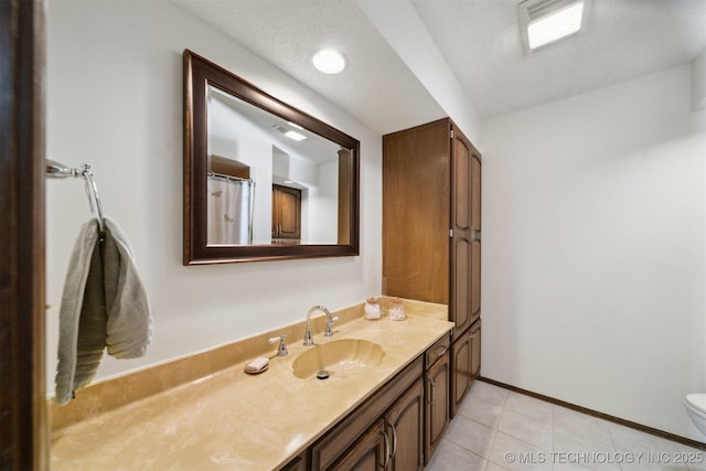 bathroom featuring tile patterned flooring, vanity, and toilet