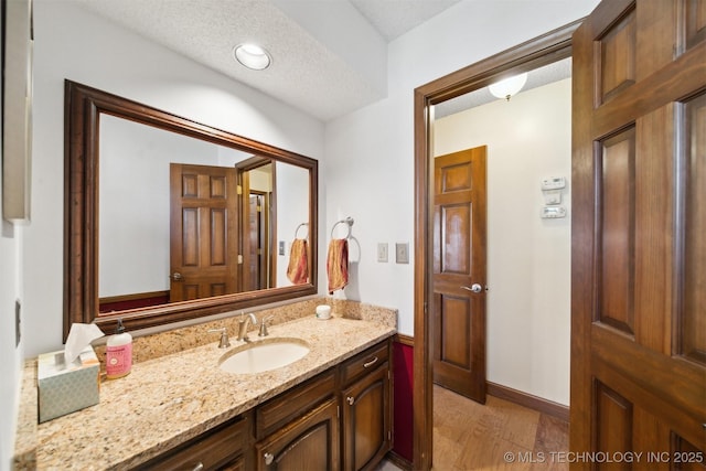 bathroom with vanity, a textured ceiling, and hardwood / wood-style flooring