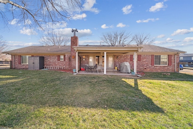 rear view of property with a lawn and a patio area