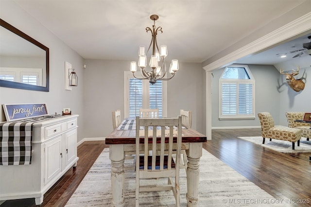 dining space featuring dark hardwood / wood-style flooring and ceiling fan with notable chandelier