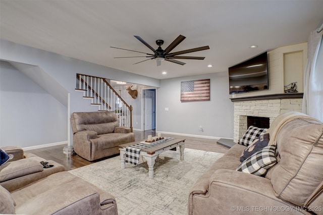 living room featuring a fireplace, hardwood / wood-style floors, and ceiling fan