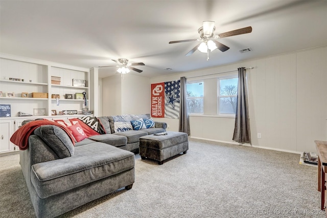 living room featuring ceiling fan, baseboards, visible vents, and light carpet