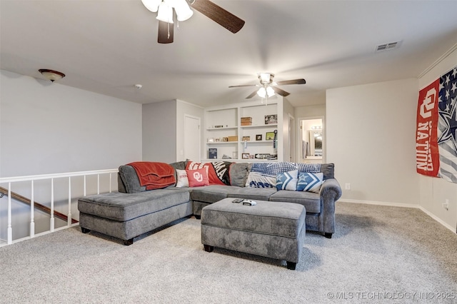 living room featuring built in shelves, ceiling fan, and light colored carpet