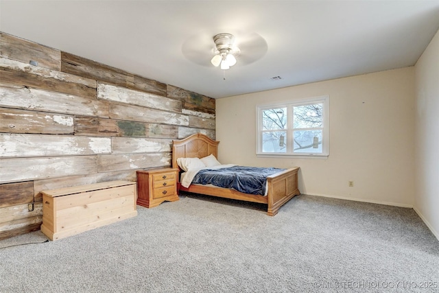 carpeted bedroom featuring wooden walls, baseboards, and visible vents