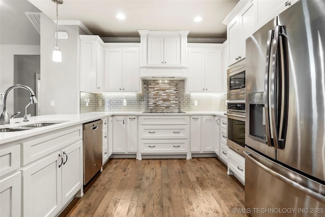 kitchen featuring dark hardwood / wood-style floors, sink, white cabinetry, hanging light fixtures, and appliances with stainless steel finishes