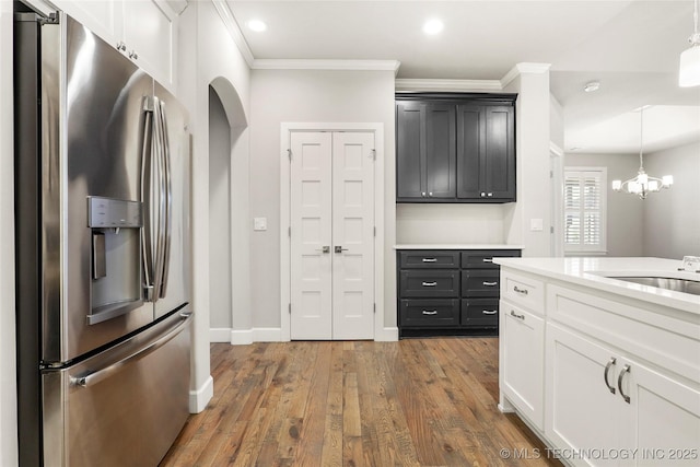 1109 W 84th Pl S, Tulsa, OK 74132 - kitchen with stainless steel fridge, light countertops, wood finished floors, crown molding, and pendant lighting
