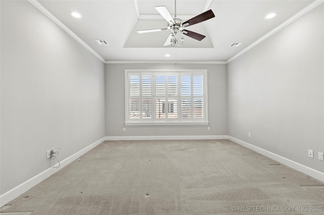 carpeted empty room with ceiling fan, ornamental molding, and a raised ceiling