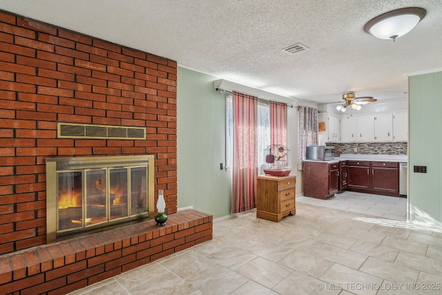 kitchen with backsplash, white cabinets, ceiling fan, a fireplace, and a textured ceiling