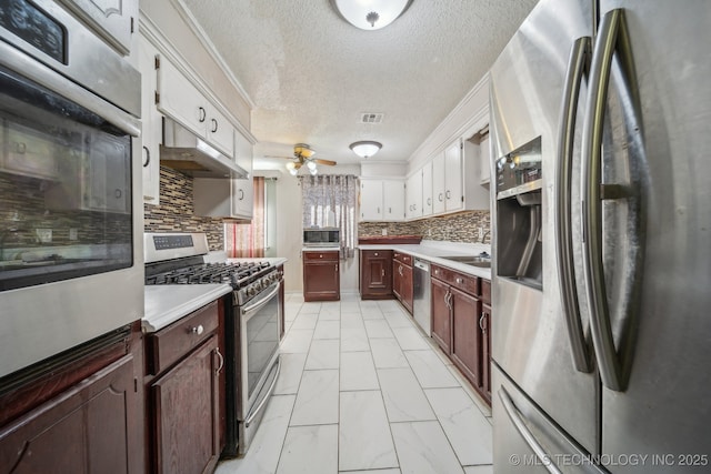 kitchen featuring tasteful backsplash, white cabinetry, sink, and stainless steel appliances