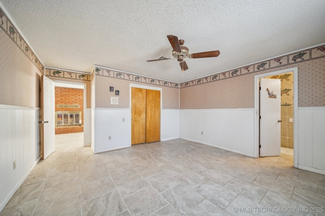 unfurnished bedroom featuring a textured ceiling, a closet, and ceiling fan